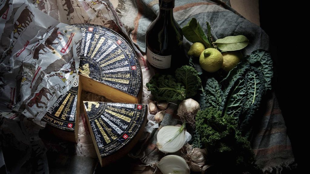 Appenzeller juustoasetelma tunnelmallisessa valaistuksessa. Mainostoimisto Halo | Helsinki x Swiss Cheese Marketing